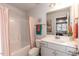 Clean bathroom with a tub shower, vanity, and coral accents at 591 Glenkirk Pl # 106, Garner, NC 27529