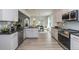 Modern kitchen with white cabinets, granite countertops, and stainless steel appliances at 591 Glenkirk Pl # 106, Garner, NC 27529