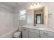 Modern bathroom with gray vanity, bathtub, and large mirror at 591 Glenkirk Pl # 106, Garner, NC 27529