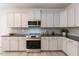 Modern kitchen with white cabinets, granite countertops, and stainless steel appliances at 591 Glenkirk Pl # 106, Garner, NC 27529