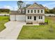 Two story home with three car garage, stone accents, and front porch at 122 Whimbrel Ct, Lillington, NC 27546