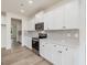 Modern kitchen with white cabinets, stainless steel appliances, and gray backsplash at 122 Whimbrel Ct, Lillington, NC 27546