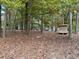 Wooded backyard with shed and view of the mobile home at 255 Roberts Ave, Henderson, NC 27537