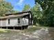 Rustic home exterior with wood siding, and a gravel driveway at 255 Roberts Ave, Henderson, NC 27537
