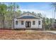 White house with a front porch and a brick base, nestled among tall trees at 325 Natchez Trce, Fuquay Varina, NC 27526