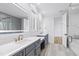 Bathroom with double vanity, gold fixtures, and view of shower at 1610 Carson St, Raleigh, NC 27608