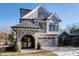 Modern two-story home with stone accents, metal roof, and paved driveway at 1610 Carson St, Raleigh, NC 27608