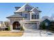 Modern two-story home with stone accents, a metal roof, and a paved driveway at 1610 Carson St, Raleigh, NC 27608