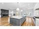 Open-concept kitchen and living room with gray island, hardwood floors, and modern lighting at 1610 Carson St, Raleigh, NC 27608