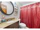 Clean bathroom with granite vanity and red shower curtain at 229 Turnipseed Rd, Wendell, NC 27591