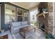 Cozy screened porch featuring a stone fireplace, comfortable seating, and natural views at 1110 Greatland Rd, Durham, NC 27703