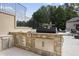 Stone outdoor kitchen with grill, side burner, and stainless steel drawers at 12660 Boyce Milll Road, Raleigh, NC 27613