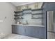 Gray wet bar with floating shelves, quartz countertop, and stainless steel appliances at 12660 Boyce Milll Road, Raleigh, NC 27613