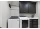 Bright laundry room with washer, dryer, and dark wood cabinets at 12660 Boyce Milll Road, Raleigh, NC 27613