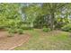 Mature trees and landscaped yard with storage shed at 613 S Fuquay Ave, Fuquay Varina, NC 27526