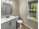 Updated bathroom with a white vanity and a large mirror at 1517 Wiljohn Rd, Garner, NC 27529