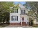 Two-story white house with red door, brick base, and landscaping at 4312 Windstorm Way, Raleigh, NC 27616