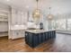 Elegant kitchen with white cabinets, blue island, and gold light fixtures at 142 Lila Dr, Pittsboro, NC 27312