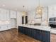 Spacious kitchen with white cabinets, gold light fixtures, and large island at 142 Lila Dr, Pittsboro, NC 27312