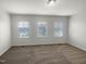 Spacious bedroom with neutral decor and three large windows at 6631 Perry Creek Rd, Raleigh, NC 27616