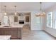 Modern kitchen with island, stainless steel appliances, and view of the living room at 10 Harvest View Way, Franklinton, NC 27525