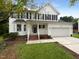 Two-story white house with gray door, brick steps, and a two-car garage at 2200 Wild Apple Ct, Apex, NC 27523