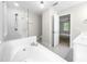 Elegant bathroom with a soaking tub, walk-in shower, and neutral tile at 2200 Wild Apple Ct, Apex, NC 27523