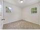 Well-lit bedroom with neutral walls, carpet flooring, and two windows at 1421 Athens Dr, Raleigh, NC 27606