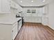 Renovated kitchen with white cabinets, stainless steel appliances, and hardwood floors at 1421 Athens Dr, Raleigh, NC 27606