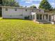 Rear view of the house showcasing a sunroom addition and expansive backyard at 1421 Athens Dr, Raleigh, NC 27606