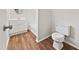 Bathroom with white vanity, toilet, and wood-look flooring at 1421 Athens Dr, Raleigh, NC 27606