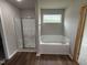 Bathroom with soaking tub, shower, and wood-look flooring at 153 Wynd Crest Way, Benson, NC 27504