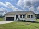 Newly built ranch home with tan siding, brown garage door and landscaped yard at 66 Tulipfield Way, Benson, NC 27504