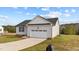 Newly built home with a white exterior, a two car garage, and a large yard at 115 Brookhaven Dr, Spring Hope, NC 27882