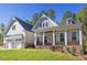 Two-story home with gray siding, brick accents, and a three-car garage at 143 Traceway N, Sanford, NC 27332