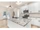 Modern kitchen with granite island, stainless steel appliances, and white shaker cabinets at 4155 Us-421, Lillington, NC 27546