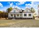 White farmhouse exterior with stone accents and a landscaped lawn at 4155 Us-421, Lillington, NC 27546