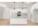 White kitchen with island, granite countertops and modern lighting at 4155 Us-421, Lillington, NC 27546