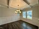 Bright dining room features hardwood floors, wainscoting, and a beautiful chandelier at 824 Putney Hill Rd, Zebulon, NC 27597