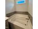Bathroom featuring a large soaking tub with gray tile surround at 824 Putney Hill Rd, Zebulon, NC 27597