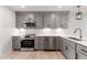 Modern kitchen featuring gray cabinets, stainless steel appliances, and white countertops at 806 S Magnolia Ave, Dunn, NC 28334