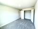 Bright bedroom with grey carpeting, a double door closet, and an adjacent bathroom at 211 Hopewell Branch Ct, Smithfield, NC 27577