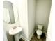 Powder room with pedestal sink, oval mirror, and neutral tile flooring at 211 Hopewell Branch Ct, Smithfield, NC 27577
