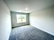 Well-lit bedroom featuring grey carpet, a window offering a view, and neutral walls at 211 Hopewell Branch Ct, Smithfield, NC 27577