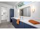 Modern bathroom with navy blue vanity, white countertop, and walk-in closet at 23930 Cherry, Chapel Hill, NC 27517