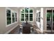 Bright dining room with large windows and a dark wood table at 9417 Rawson Ave, Raleigh, NC 27613