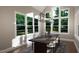 Bright dining room with large windows and a dark wood table at 9417 Rawson Ave, Raleigh, NC 27613
