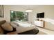 Bright bedroom with large windows, dresser, and TV at 9413 Rawson Ave, Raleigh, NC 27613