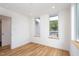 Simple bedroom with hardwood floors and two large windows at 515 W Lenoir St # 101, Raleigh, NC 27601