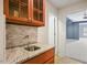 Basement wet bar with granite countertop and wood cabinets at 15 Meadow View Ct, Fuquay Varina, NC 27526